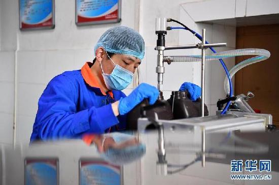在山西省太原市的太原格丽特日化有限公司,员工在灌装消毒液(2月13日摄)。新华社记者 詹彦 摄