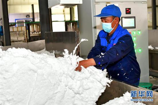 搬迁户曹六仁在岢岚县一家玻璃棉厂的生产线上工作(5月20日摄)。 新华社记者 曹阳 摄