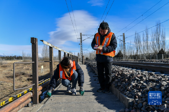1月12日，中國鐵路太原局集團有限公司大同工務段的橋隧工趙辰妍（左）和工長張海利測量京包鐵路一座鐵路橋的步行板。