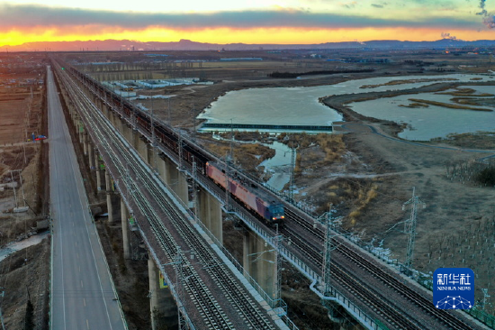 一列運輸煤炭的重載列車行駛在大秦鐵路御河橋上（1月12日攝，無人機照片）。