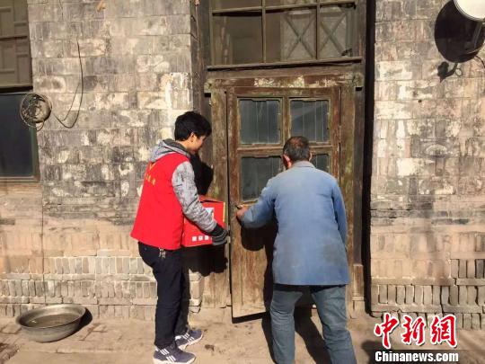 志愿者帮老人将物品搬回家。 李泊萱 摄