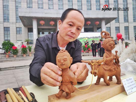 民间手艺人在完善木雕作品《喜迎新娘》 摄影:郝智祥