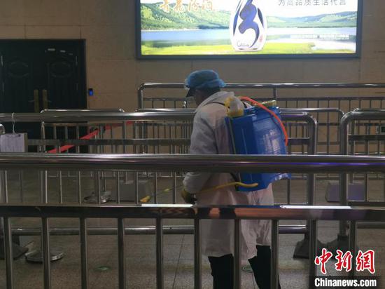山西对办公、社区、公共交通工具等11类场所提出具体消毒要求。图为太原火车站出站口,工作人员正在进行消杀作业。 高瑞峰 摄