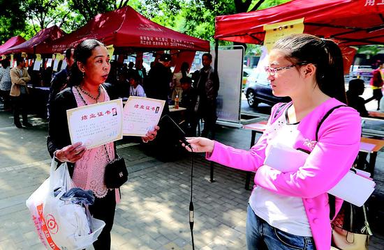 经过“吕梁山护工”专业技能培训的李女士前来参加护工专场招聘会,她开心地给记者展示她和同伴的结业证书。赵泉 摄