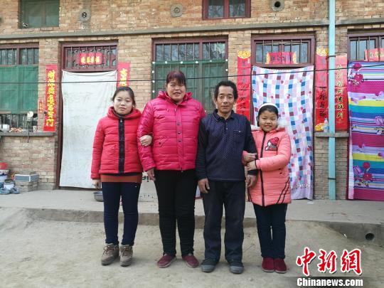 山西省太原师范学院教师朴巍邀请摄影记者进入山西的农村,为20户贫困户拍摄全家福。图为大涧北村村民沈跃军一家四口。武俊杰 摄