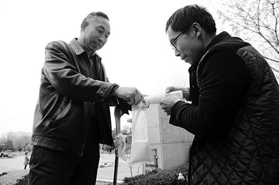 将挤好的奶给顾客倒进袋子里,因为人好、奶的质量也好,潘师傅有了不少老顾客。