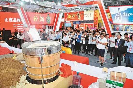 5月18日,在安徽合肥滨湖国际会展中心10号馆举行的山西品牌中华行(合肥站)迎来大批游客及当地市民的光顾,大家尝美食、购商品,对山西商品赞不绝口。山西品牌借助中博会的舞台大放异彩。图为游客正在观看汾酒集团现场酿酒。 记者 马立明 摄影报道