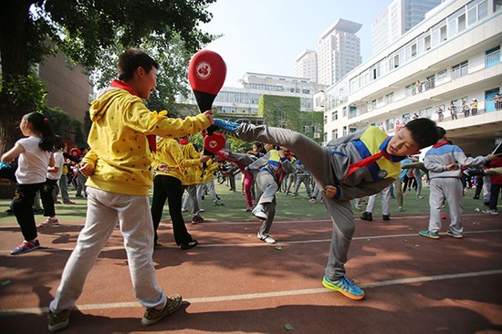 学生们在体育课上学习跆拳道。