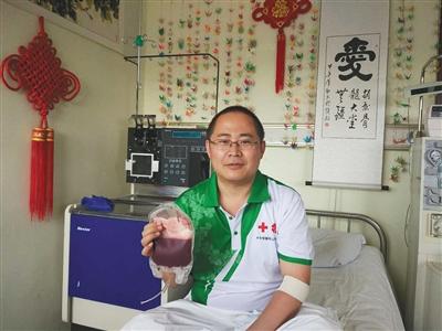 捐献完毕后,王炳效手拿从他血液中分离出的造血干细胞混悬液。受访者供图