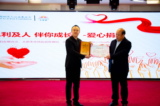 图为太原市社会(儿童)福利院院长张毅敏为无限极山西分公司赠送牌匾和证书