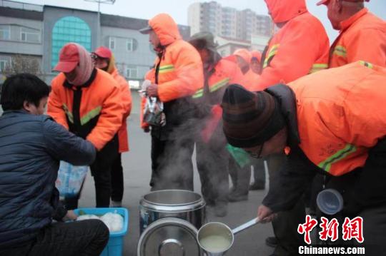 26日早上7点多,山西省长治市长子县市场监督管理局附近,已经在寒风中工作了两三个小时的环卫工人们排着队领取热腾腾的早饭。长子县新闻中心 供图
