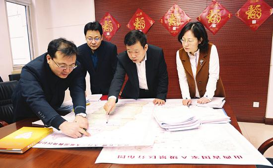 王文保(右二)正与相关人员研究黄河、太行、长城三大旅游板块的开发事宜。(资料图)