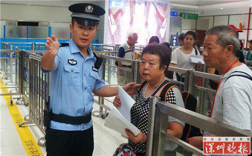 ▲边检民警在皇岗口岸出境大厅热情帮助旅客通关咨询。黄俊生摄