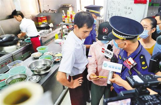 在金泰轩食府,执法人员开具了整改通知书,限期整改。 深圳商报记者 廖万育 摄