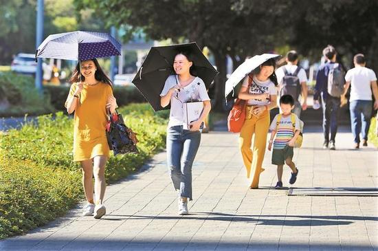 ▲烈日下，市民打伞出行。深圳晚报见习记者 杨少昆 摄