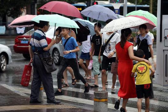 吉华路上，市民打伞出行。