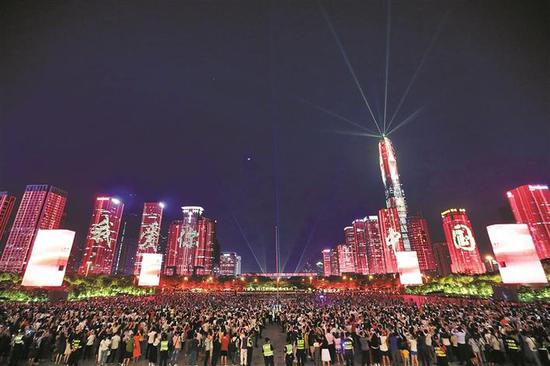 绚丽的灯光在高楼大厦间打出“我爱你中国”字样。