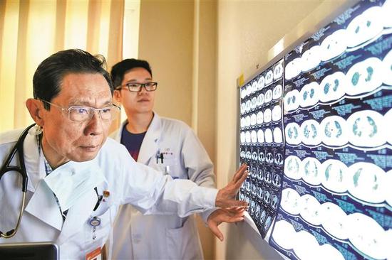 ▲钟南山院士在广州医科大学附属第一医院的诊室内查看X光片。新华社 发