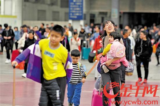 大年初四,广州火车站。 当日中午近 30℃的高温让返程旅客不太适应,出站后纷纷脱去厚衣服 金羊网记者 宋金峪 摄