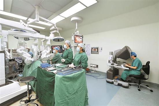 在手术台上，机械臂正根据指令精准完成手术动作。 主刀医生通过控制台向机械臂发出指令。