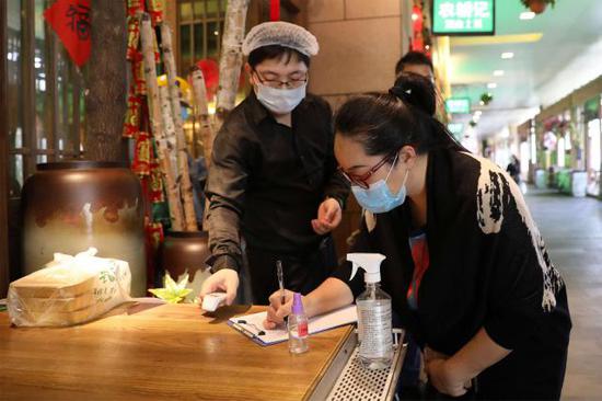 ▲顾客到店堂食需要登记个人基本信息及记录体温检测结果。