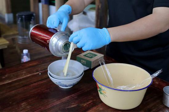 ▲餐厅工作人员在顾客餐前进行碗筷消毒工作。