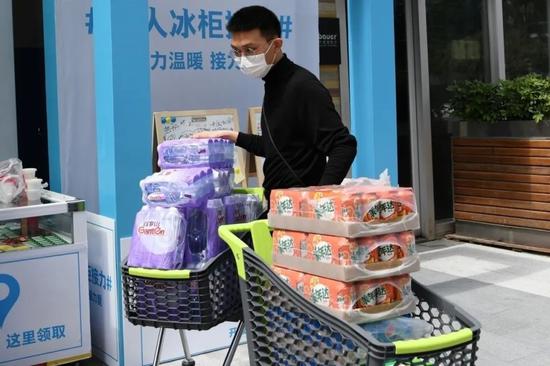 2月29日，一位市民采购饮品后委托超市工作人员送到“无人冰柜”。新华社记者 梁旭 摄