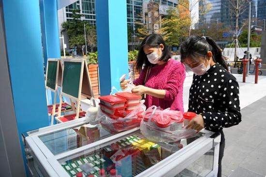 2月29日，市民捐赠10份午餐，并细心地解开塑料袋的结。新华社记者 梁旭 摄