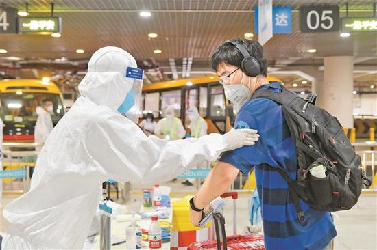 在机场分流点,工作人员为旅客贴上分流标签。