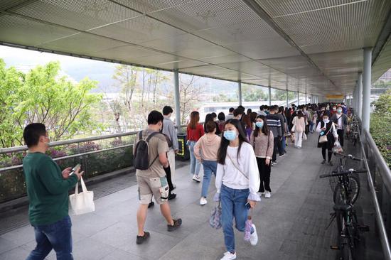▲民乐附近的人行天桥上,上班的人群脚步匆匆。