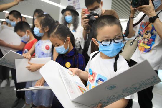 ▲孩子们收到了儿童专列的活动纪念徽章