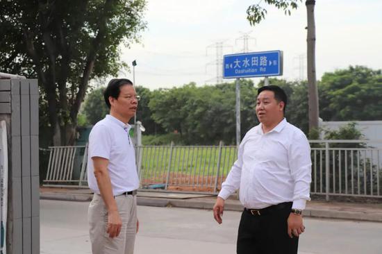 百色市委常委、副市长李联成(左)与项目负责人郭玉亮(右)在项目部进行交流