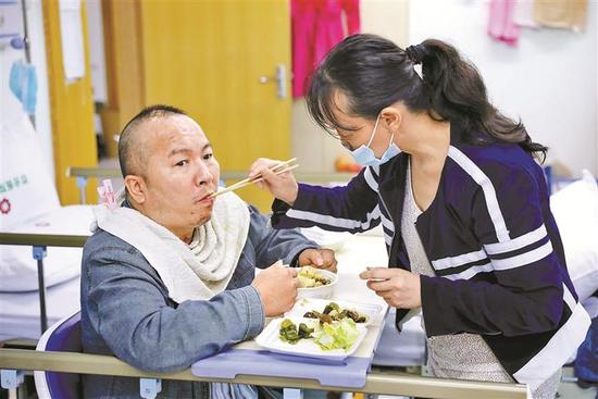 ▲吴琼悉心照料杨猛吃饭。