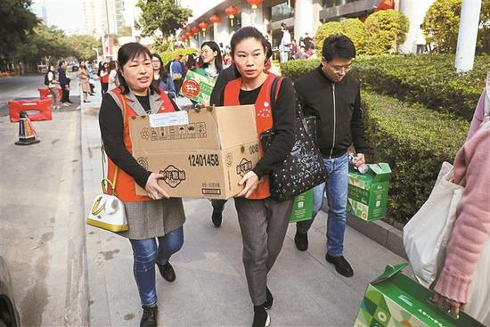 ▲志愿者搬运爱心年夜饭礼包。深圳晚报记者 杨少昆 摄