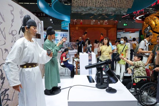 5月22日,观众在文博会辽宁展台观看机器人表演。(梁旭 摄)