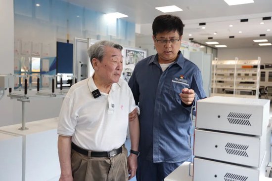刘晨光(左)和年轻同事交流电力系统最新设备应用。 深圳特区报记者 苗威 摄