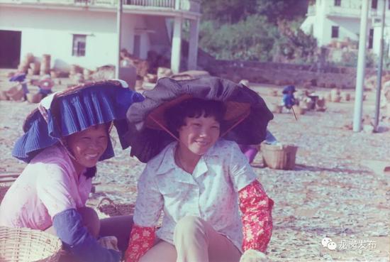 ▲1982年，深圳东部沿海大鹏镇，翻晒渔获的渔家女子。