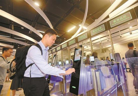 ▲在香港西九龙站,乘客在使用自动闸机办理离港通关。新华社 发