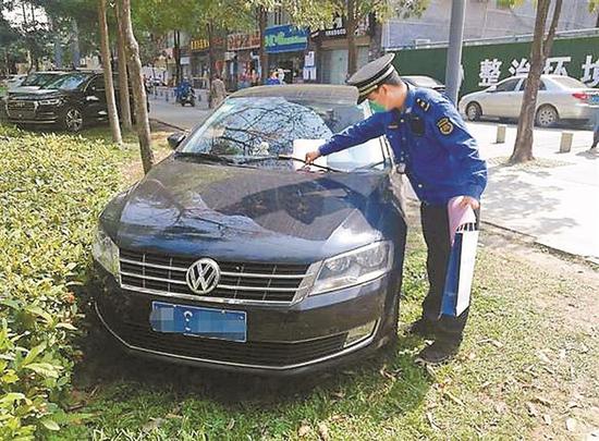 执法人员在违停车辆上放置“温馨提示”。 市城市管理和综合执法局供图