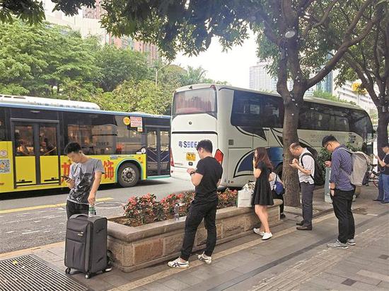◀深南东路南侧大剧院地铁站E出口处公交车道上,网约大巴在此揽客,导致其后的公交车无法通过公交车道进站,只好绕道进站。