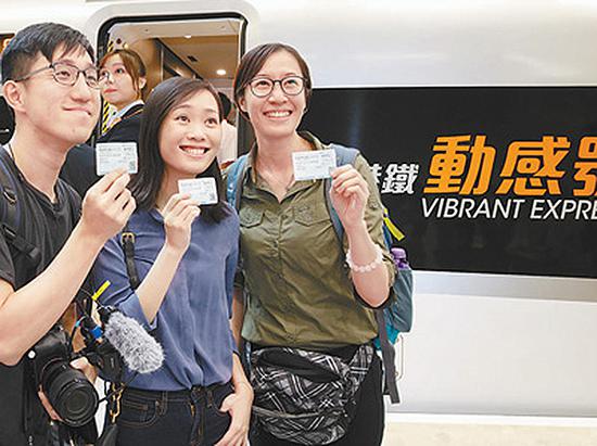 9月23日,香港乘客在“动感号”列车前留影。当日,广深港高铁香港段正式开通运营。 史家名 图