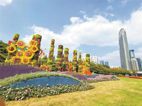 在深南大道竹子林路段,主题为“团结向上谋发展”的绿雕抢眼且富有寓意。