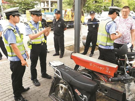 执法人员查扣违法上路摩托车。