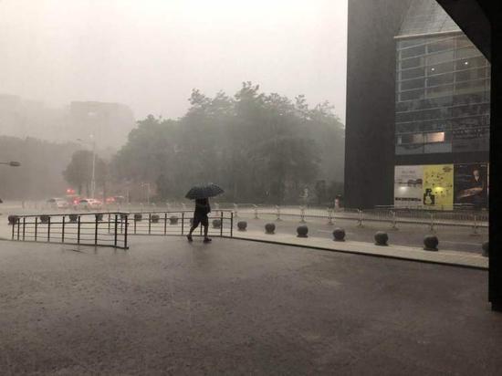 　△11日下午5时许，市民中心附近暴雨中赶路的市民。读创╱深圳商报记者 严文婷 摄