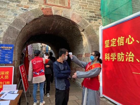 ▲南山区青年突击队员在南头街道古城为来往行人检测体温
