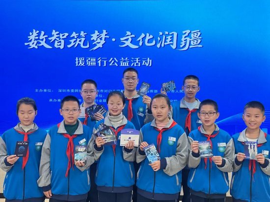 学生通过手机轻触NFC明信片，即可随时随地观看对应的科普课程视频。董晓 摄