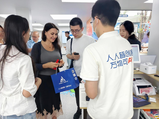 拿麦K歌的外国友人爱不释手，现场下单了一台AI音响打包带回家。（叶惠玲 摄）