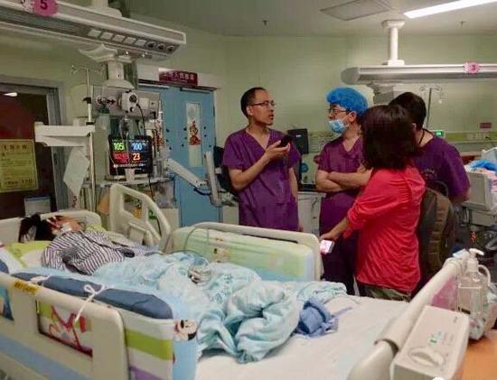 ▲广东省微生物研究院的李泰辉、邓旺秋在儿童医院看望中毒患者。