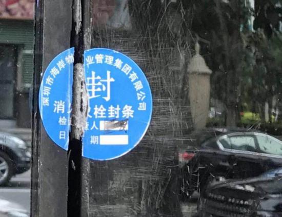 消火栓箱上的封条上，印有“深圳市海岸物业管理集团有限公司”字样。