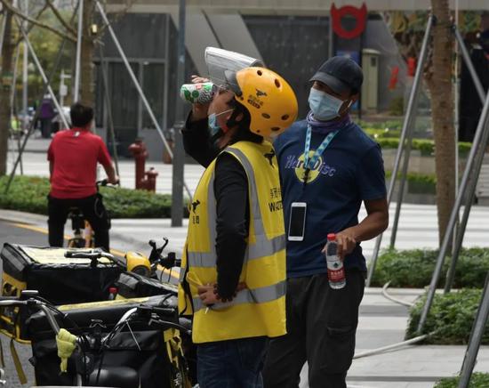 2月29日，领取饮品后，外卖小哥在路边一饮而尽。新华社记者 赵瑞希 摄